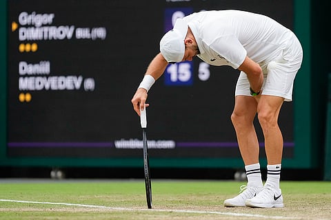 Grigor Dimitrov reacts after injuring his leg